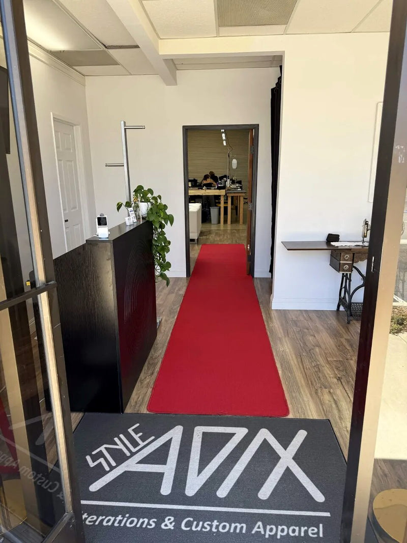 The entrance to the Style Adix studio, red carpet and branded floor mat leading through to the workroom