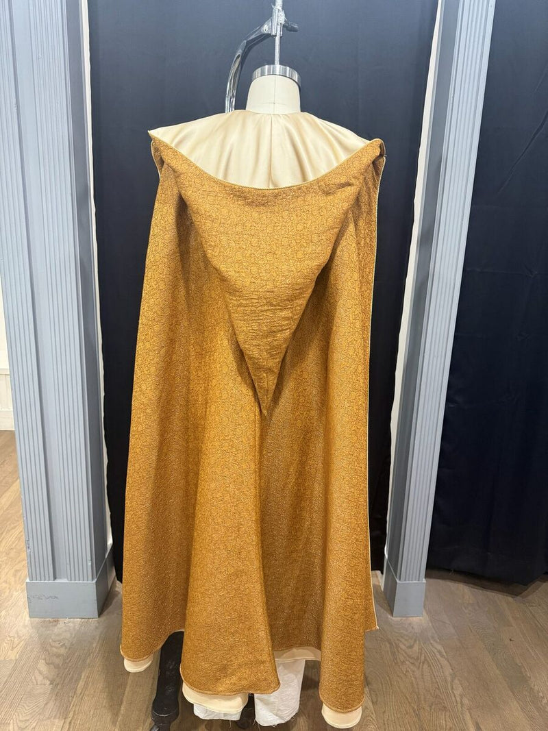 Gold brocade hooded cloak on a dress form