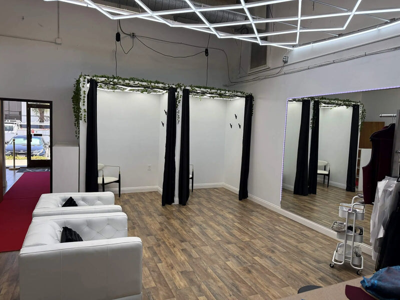 The Style Adix fitting rooms, with black curtains, trailing ivy and a geometric ceiling light