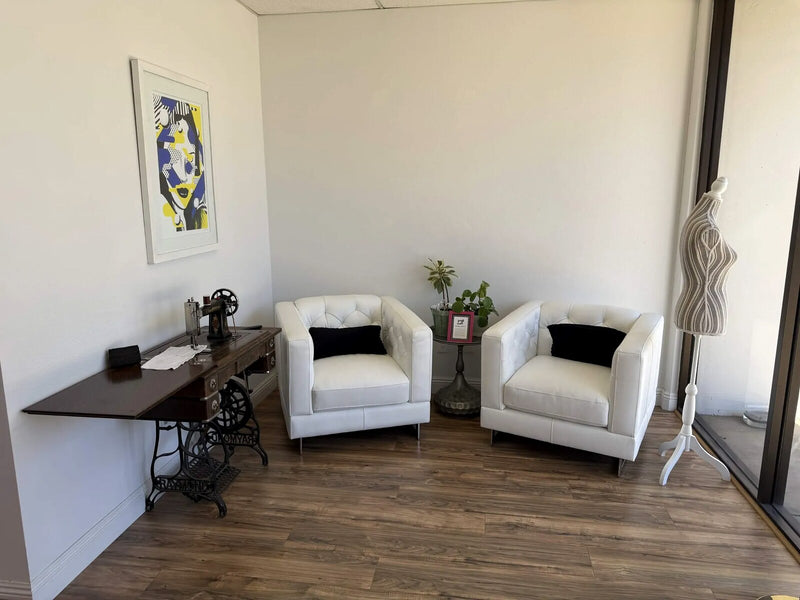 The studio lounge, with an antique treadle sewing machine, armchairs and a dress form